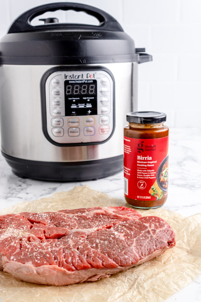 birria cooking sauce and chuck roast in front of instant pot