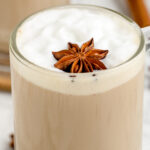 Coffee Chai in a glass mug with a layer of foam and a piece of whole star anise on top